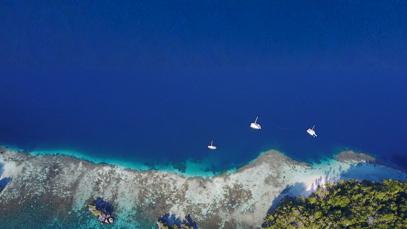 Catamarans anchored over a reef